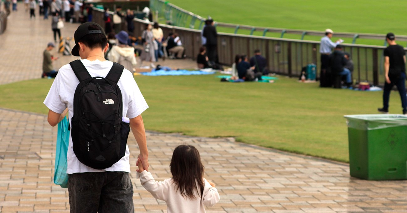 手をつないで歩く親子の後ろ姿