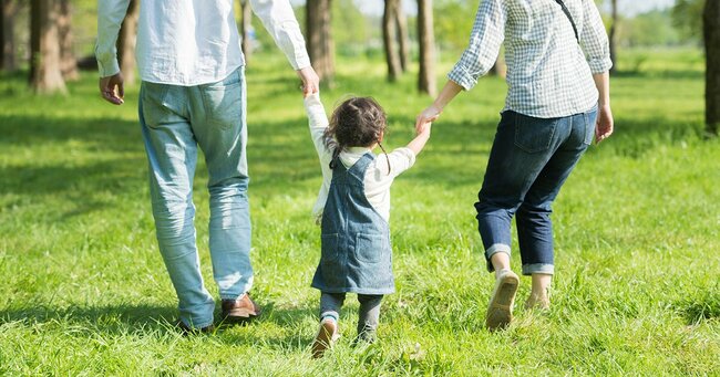 両親に手を引かれる子ども