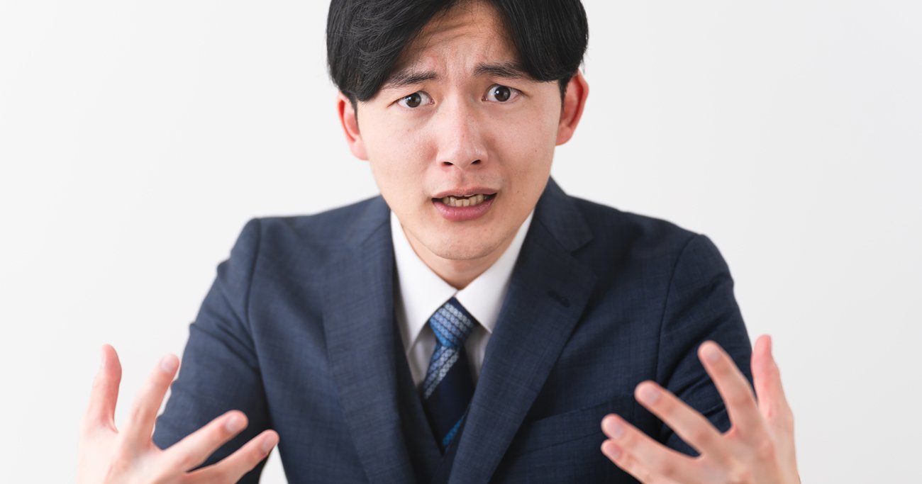 困惑した表情で訴えかけるビジネスマン