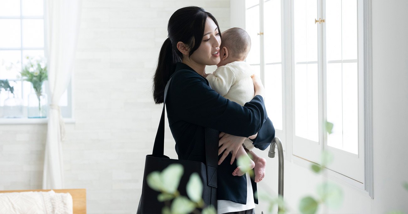 子どもを抱っこするワーキングマザーのイメージ写真