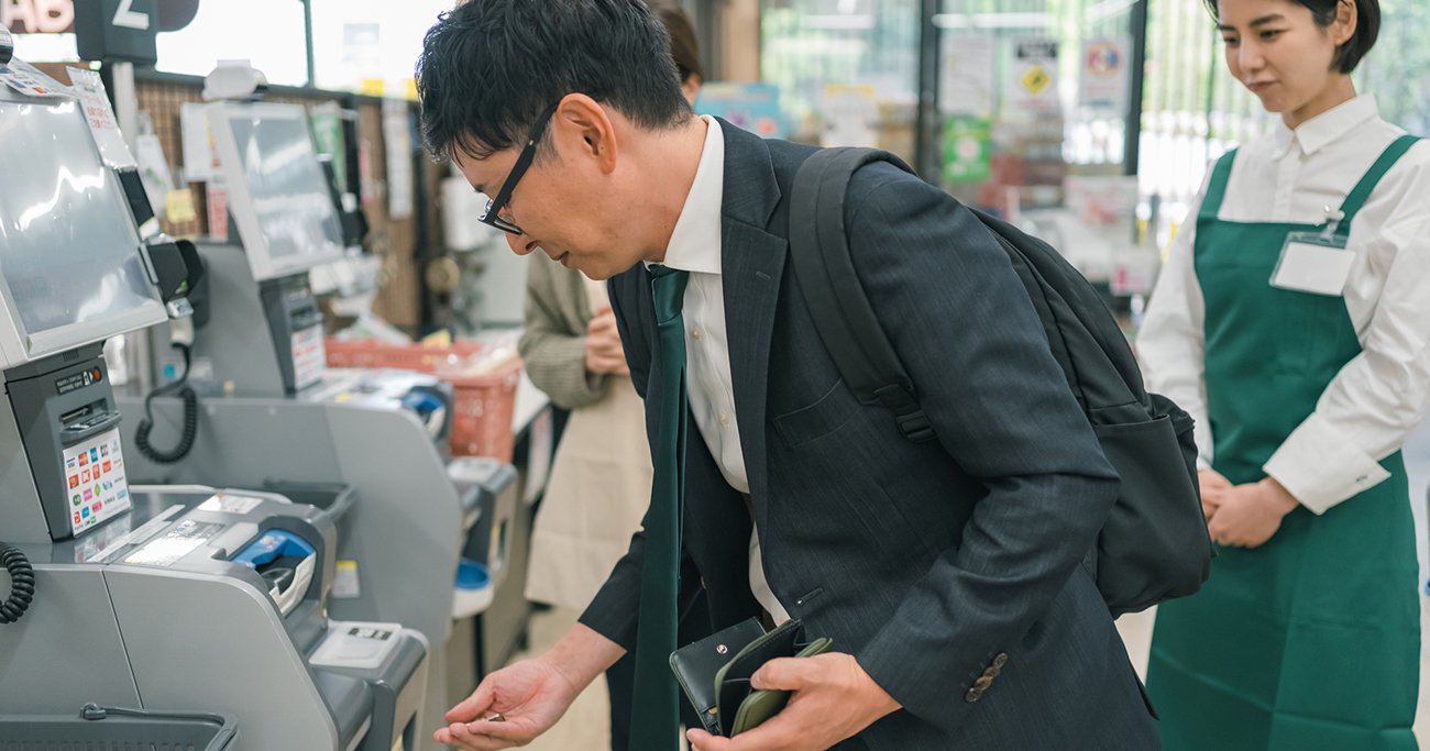 セルフレジで会計するスーツ姿の男性