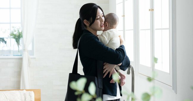 子どもを抱っこするワーキングマザーのイメージ写真