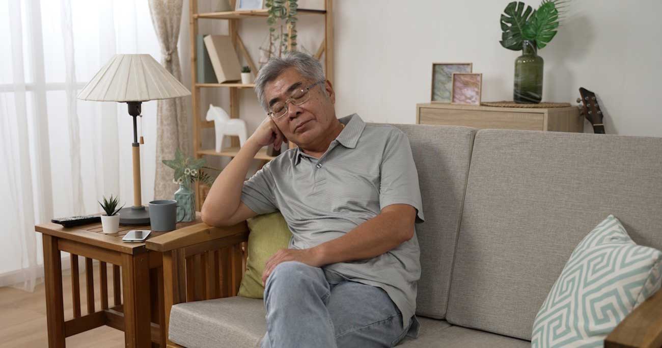 目を閉じ足を組んでいる男性