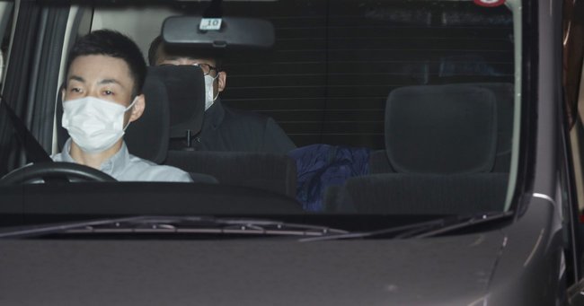 送検のため京都府警・中京署を出る大久保愉一容疑者（中央奥）を乗せた車（7月24日撮影）　Photo:JIJI
