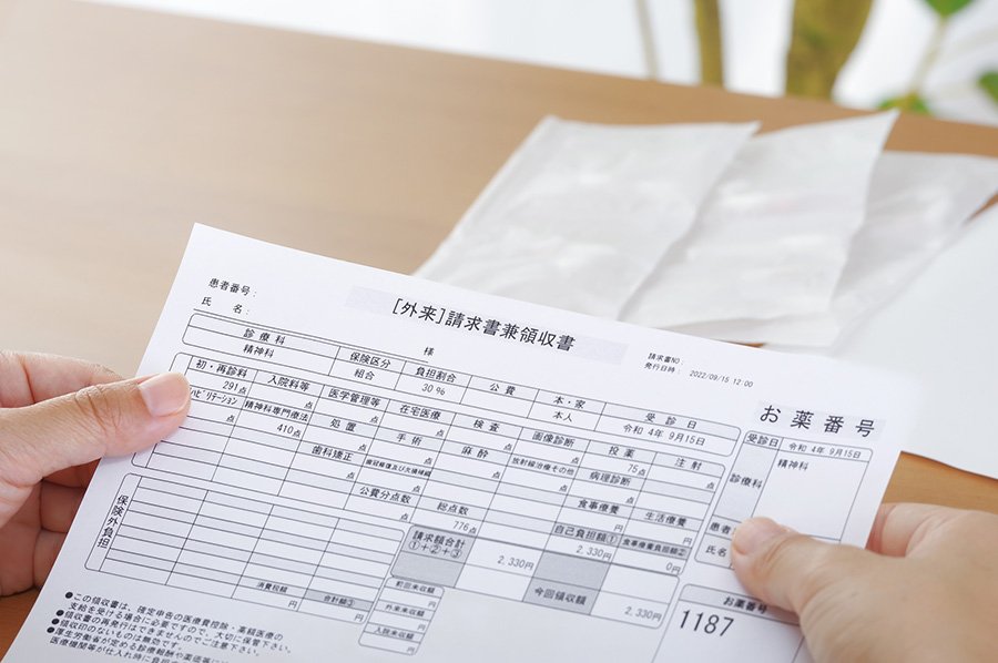 医療費の請求書を持つ手