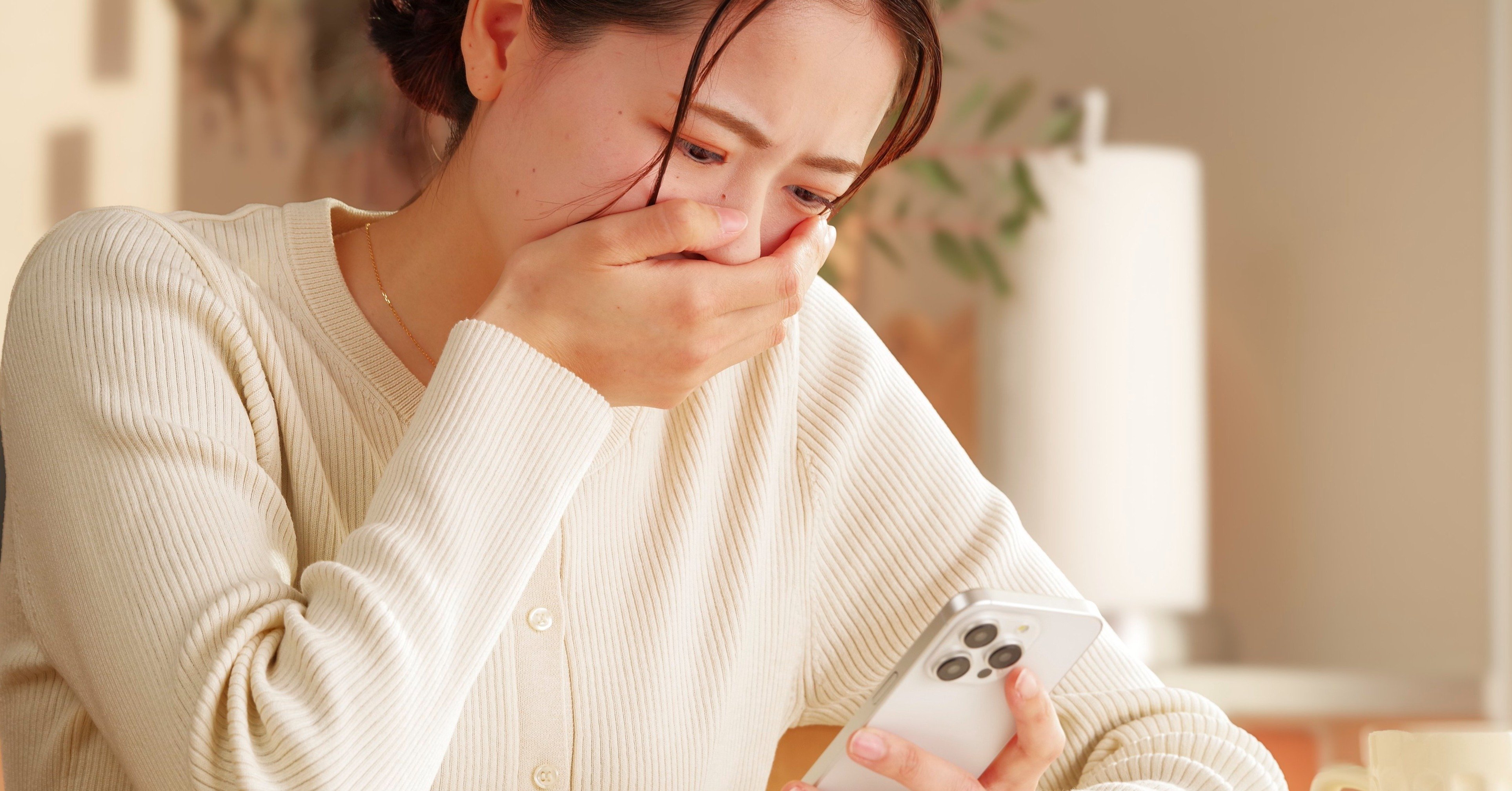 スマホを見て涙を流す女性