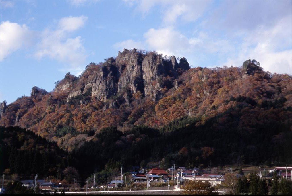 岩櫃城がある岩櫃山の遠景/岩櫃城は岩櫃山の北東に延びる尾根に位置する。東は吾妻川、西は岩櫃山、南は吾妻川へ下る急斜面、北は岩山という要害