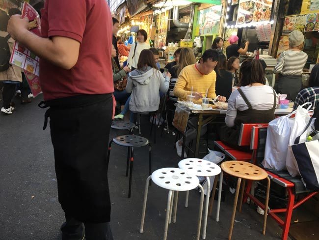 店舗間の競争も激化。せり出すテーブルと椅子で混雑時はいっそう歩きにくくなる