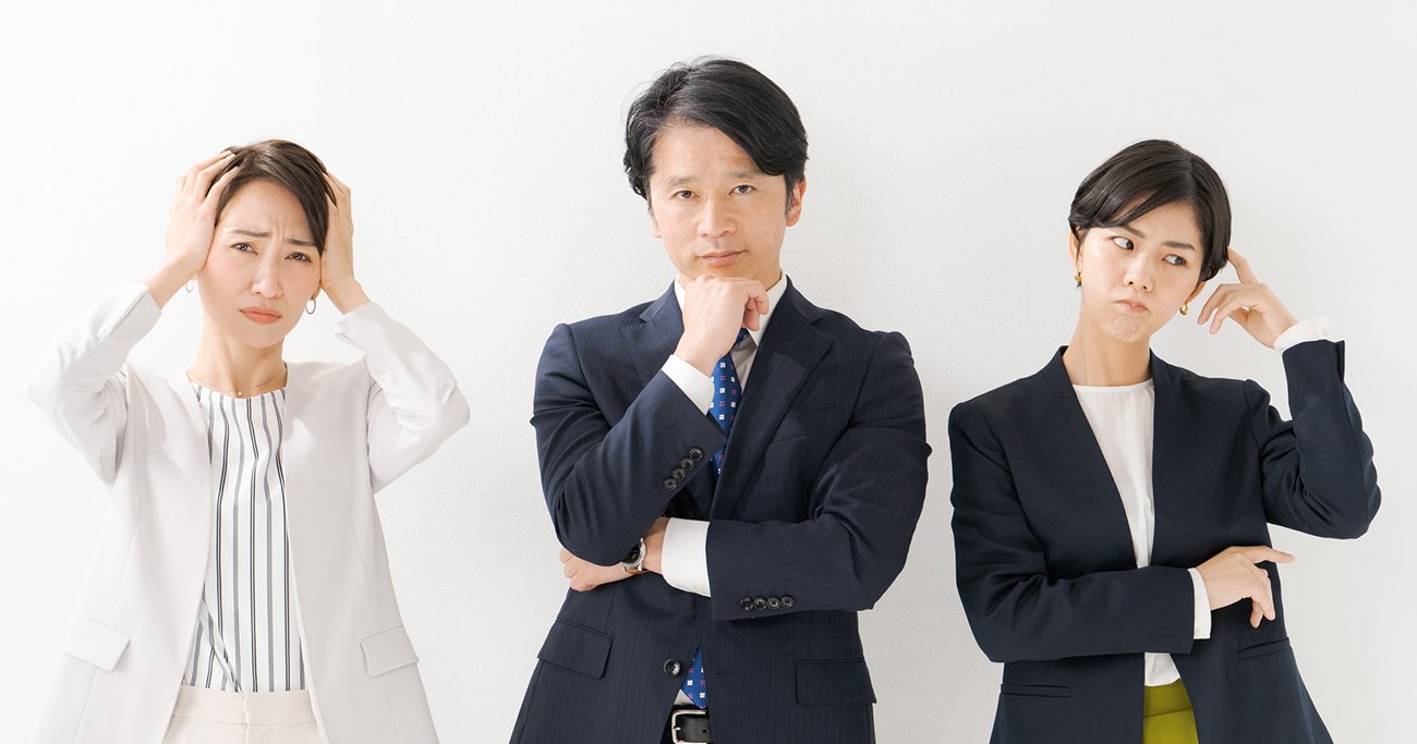 困惑した表情で考え込む男女3人