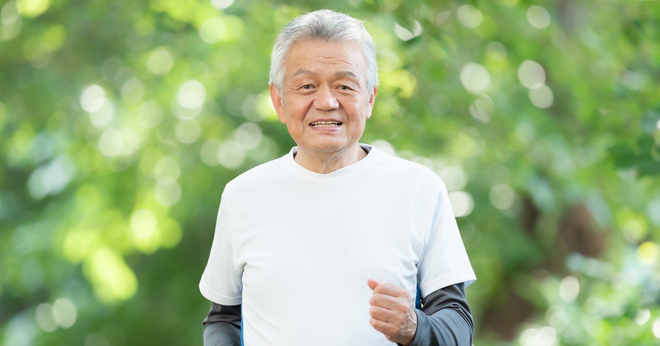 緑のある屋外で運動する高齢男性