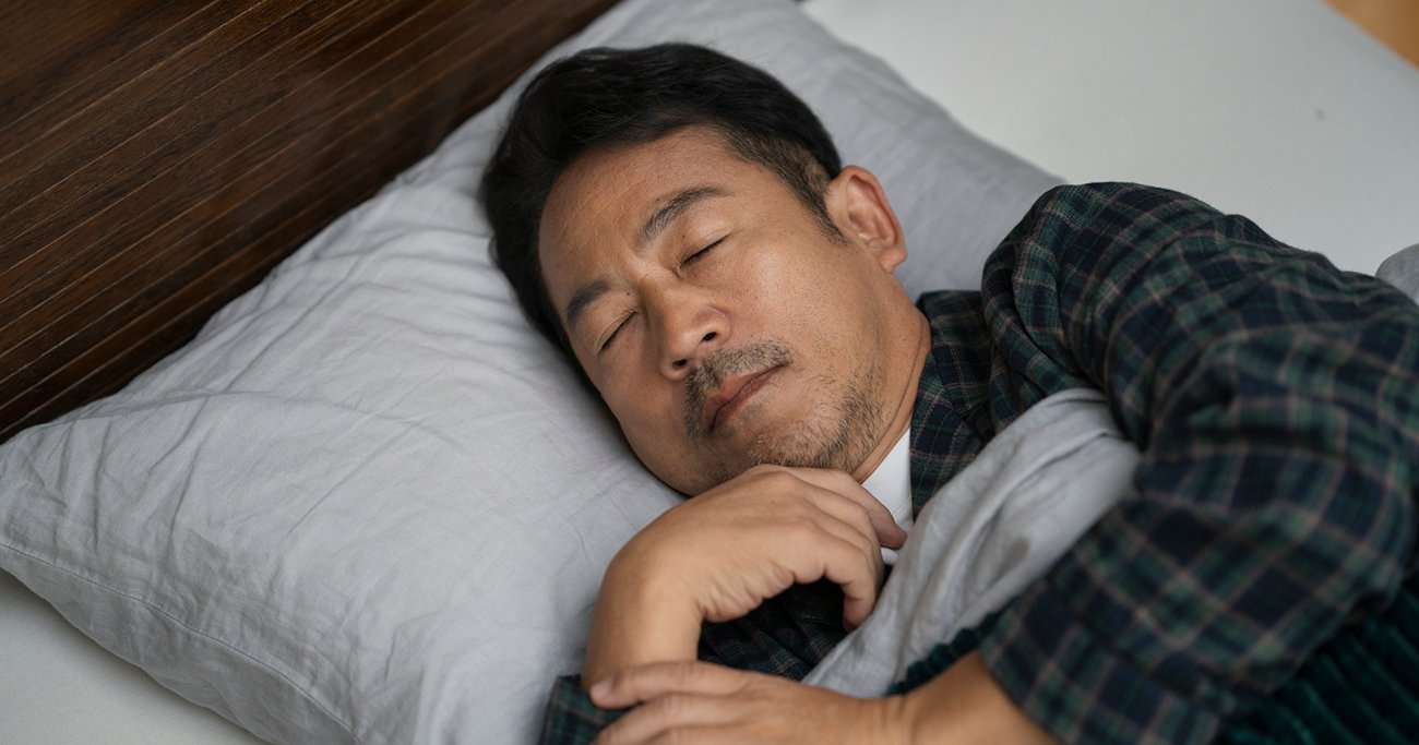 ベッドで眠る中年男性