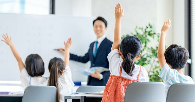 挙手をする小学生たち