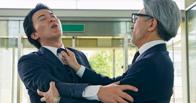 口論して揉み合うビジネスパーソン