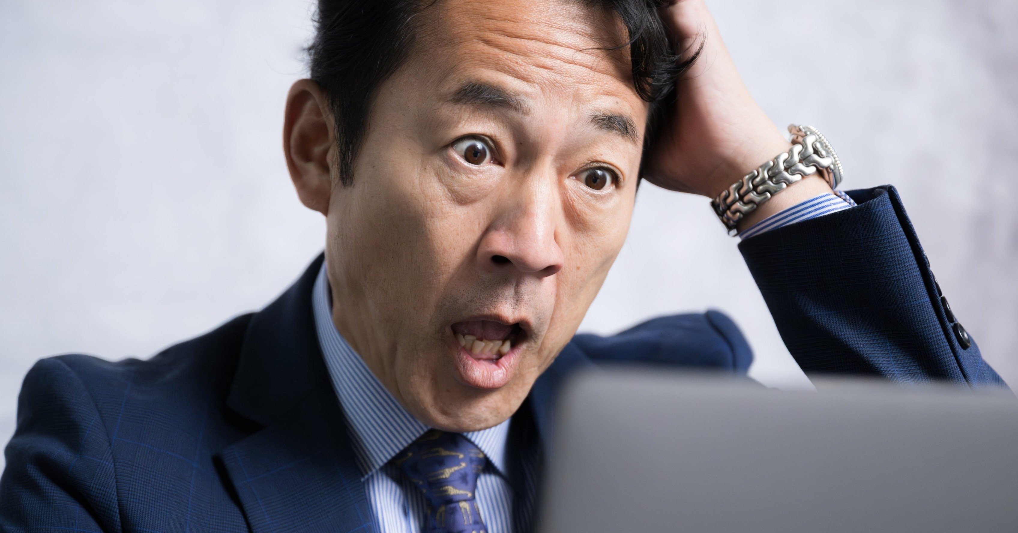 頭を抱えるスーツ姿の男性