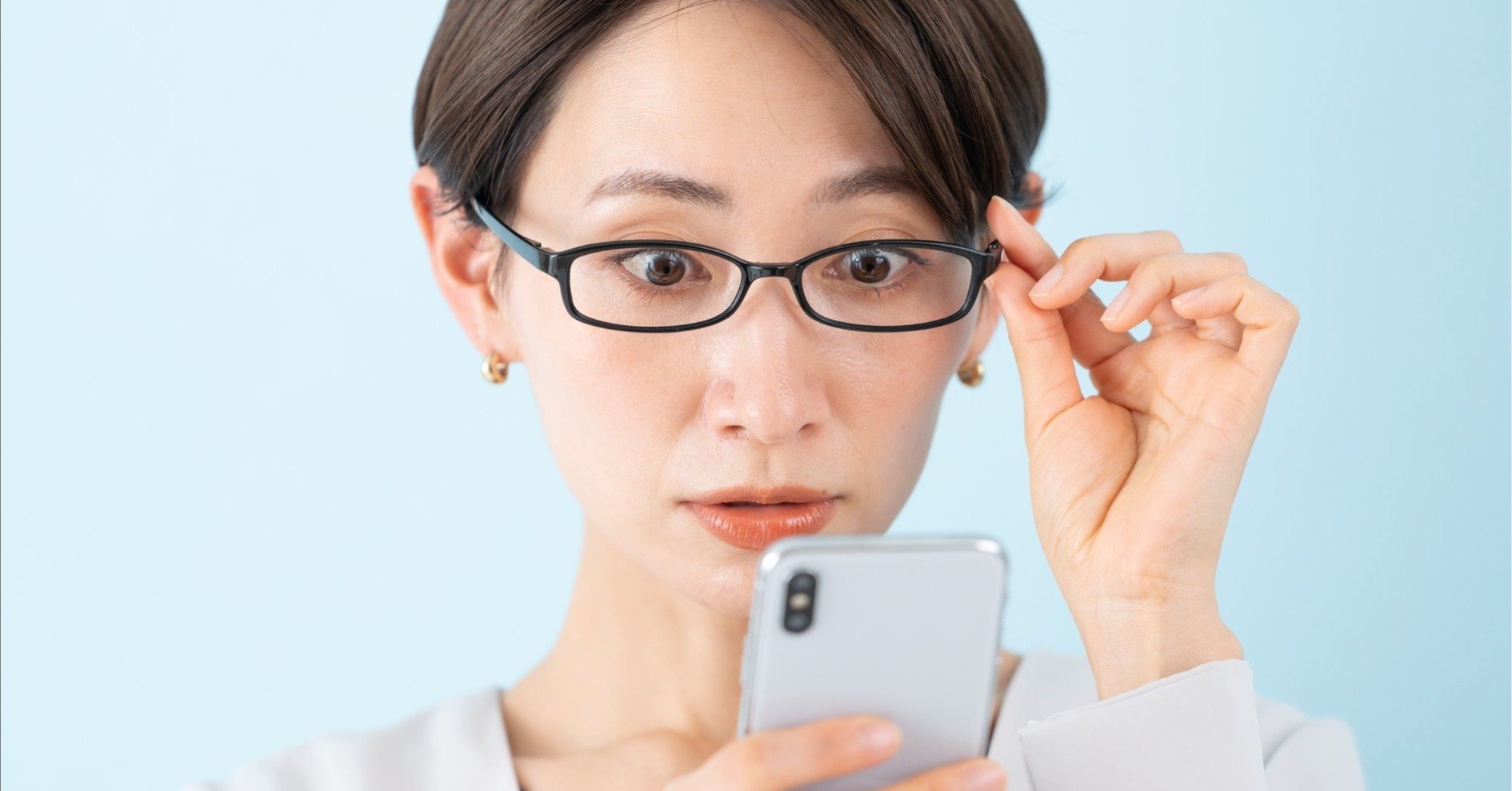スマホを見て驚く女性