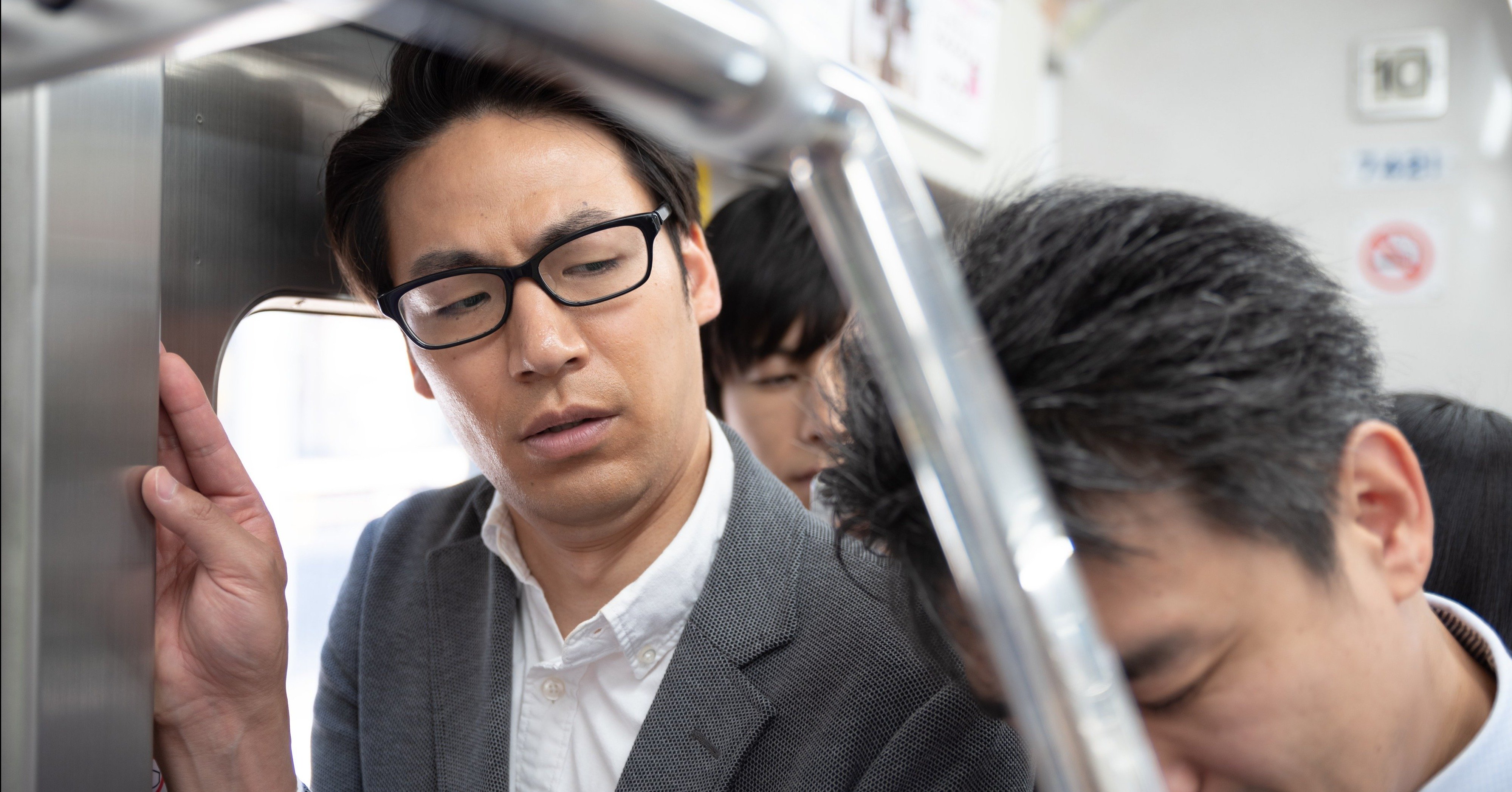 電車のドア付近に立つ人