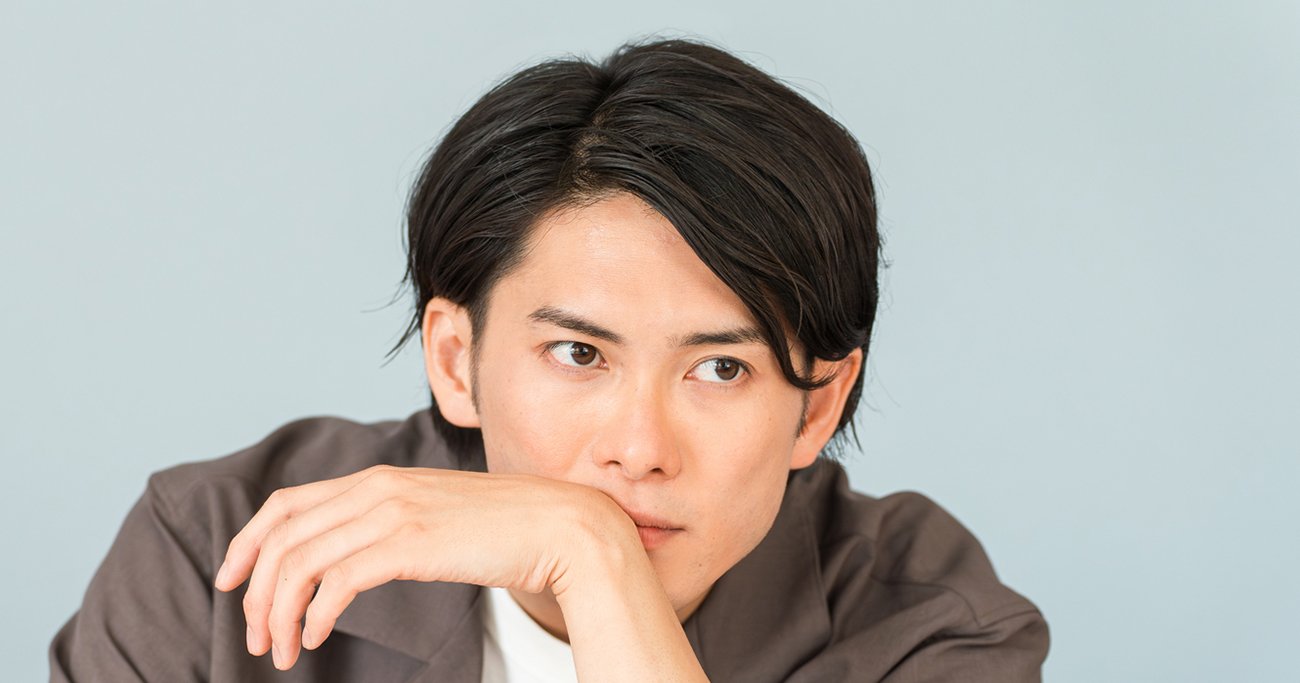 座りながらポーズを取る男性
