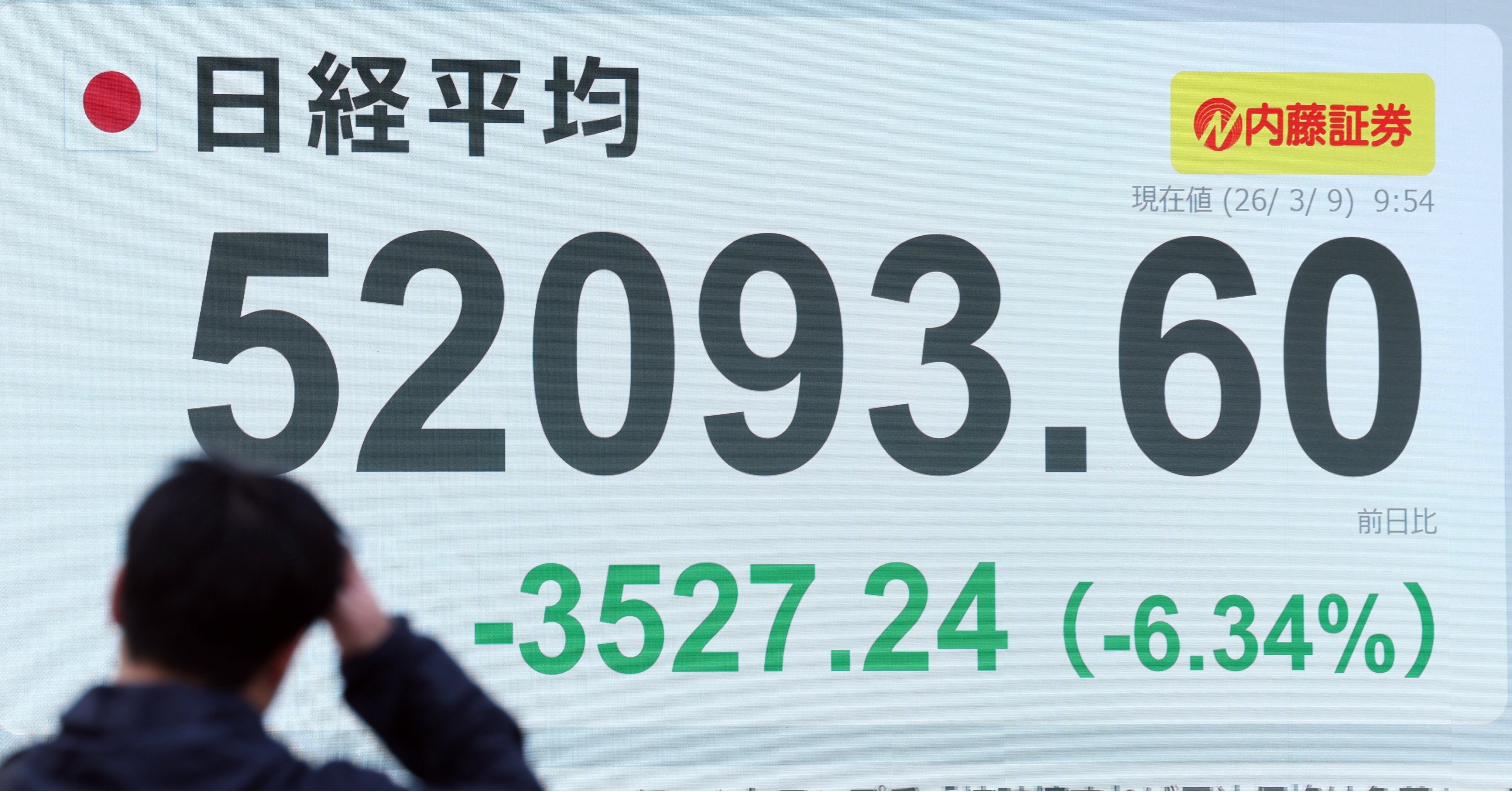 株価ボードを眺める人