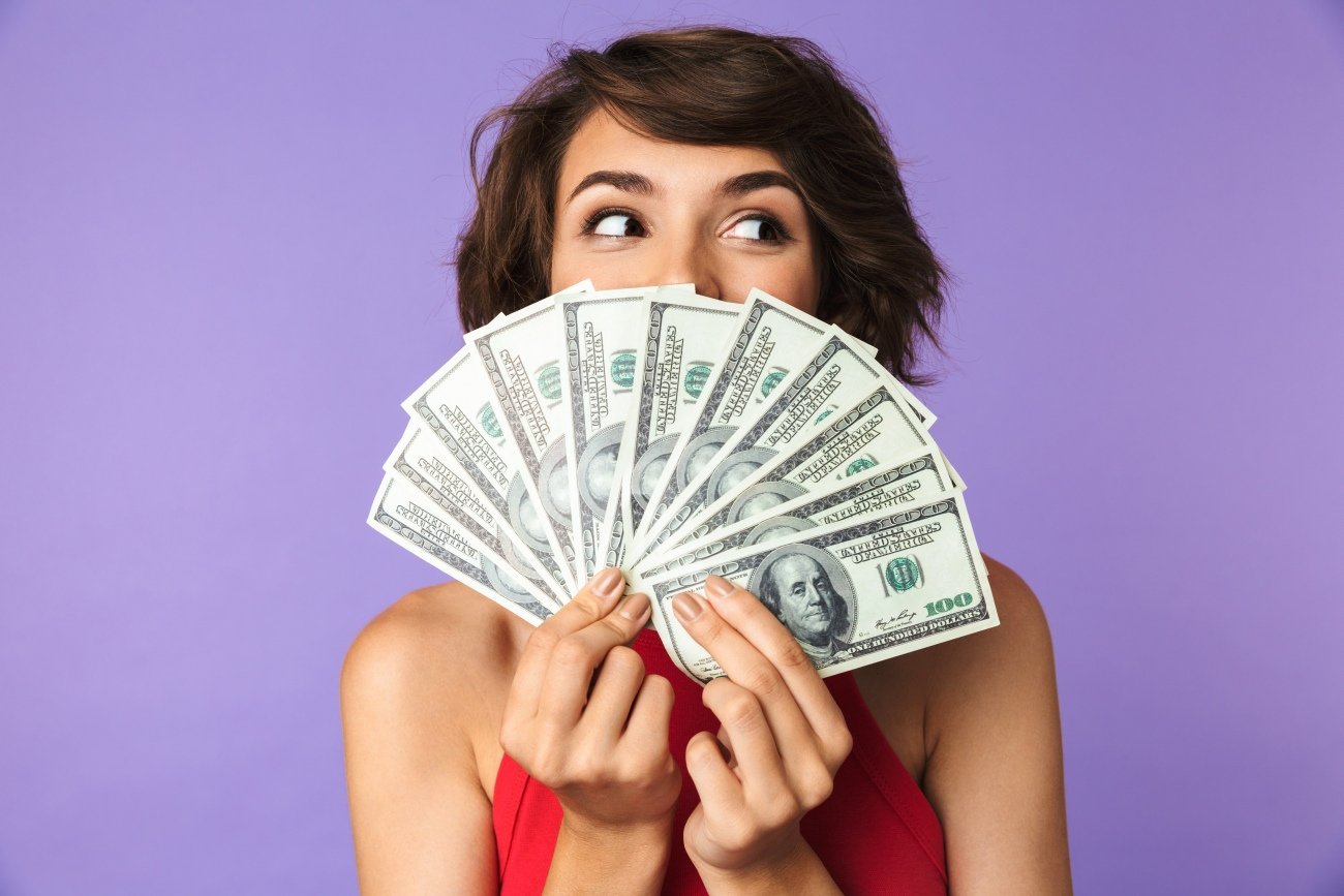 Happy Pretty brunette woman covering her face with money