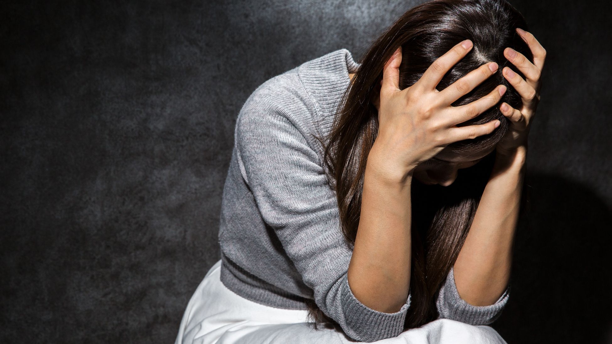 絶望し、頭をかかえる女性