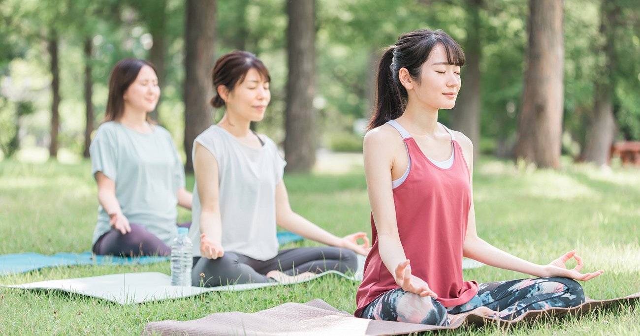 芝生の上で静かに瞑想する女性たち