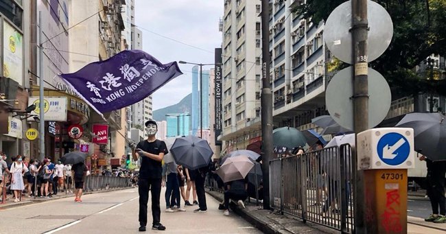 香港の独立を訴える旗を振る人