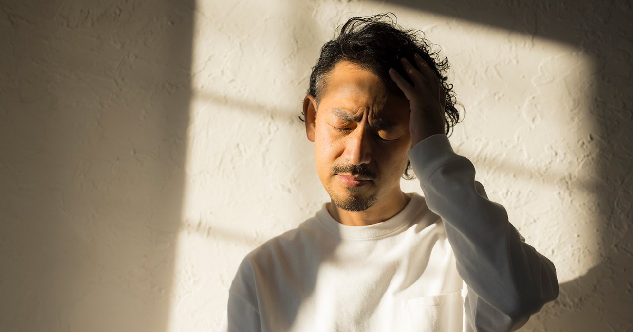 頭を抱えて悩む男性