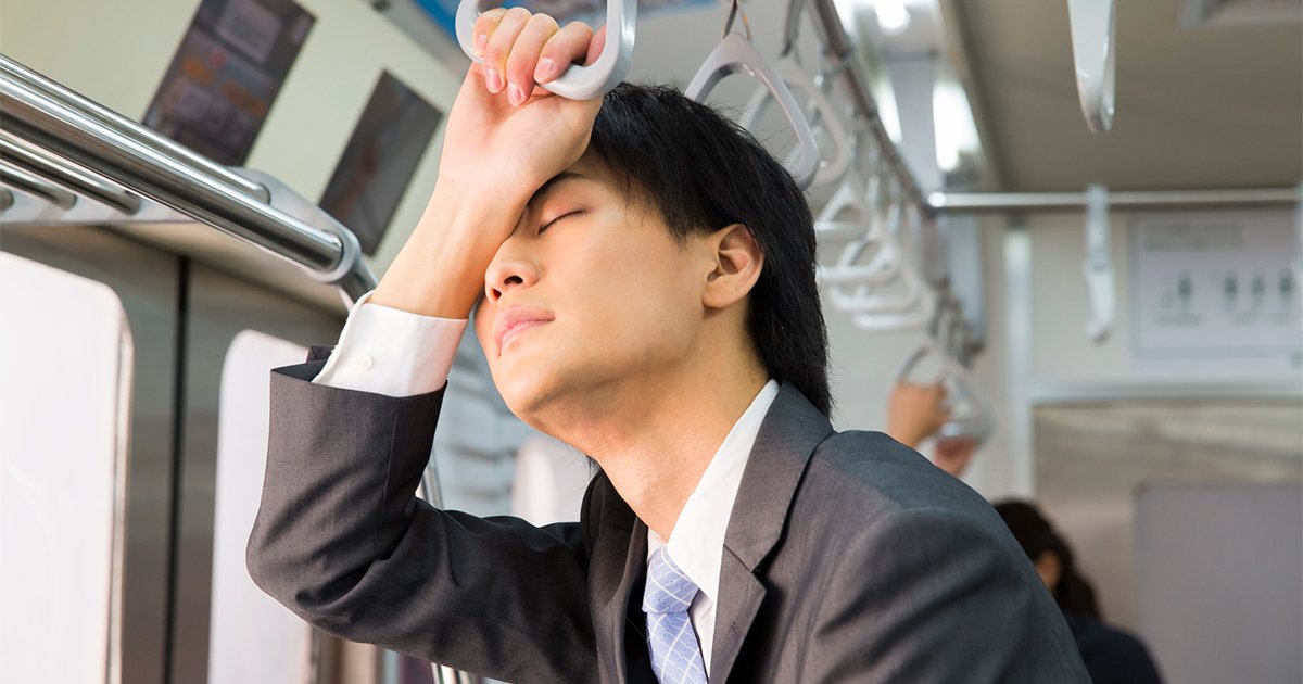 電車内で立ったまま寝るビジネスマン