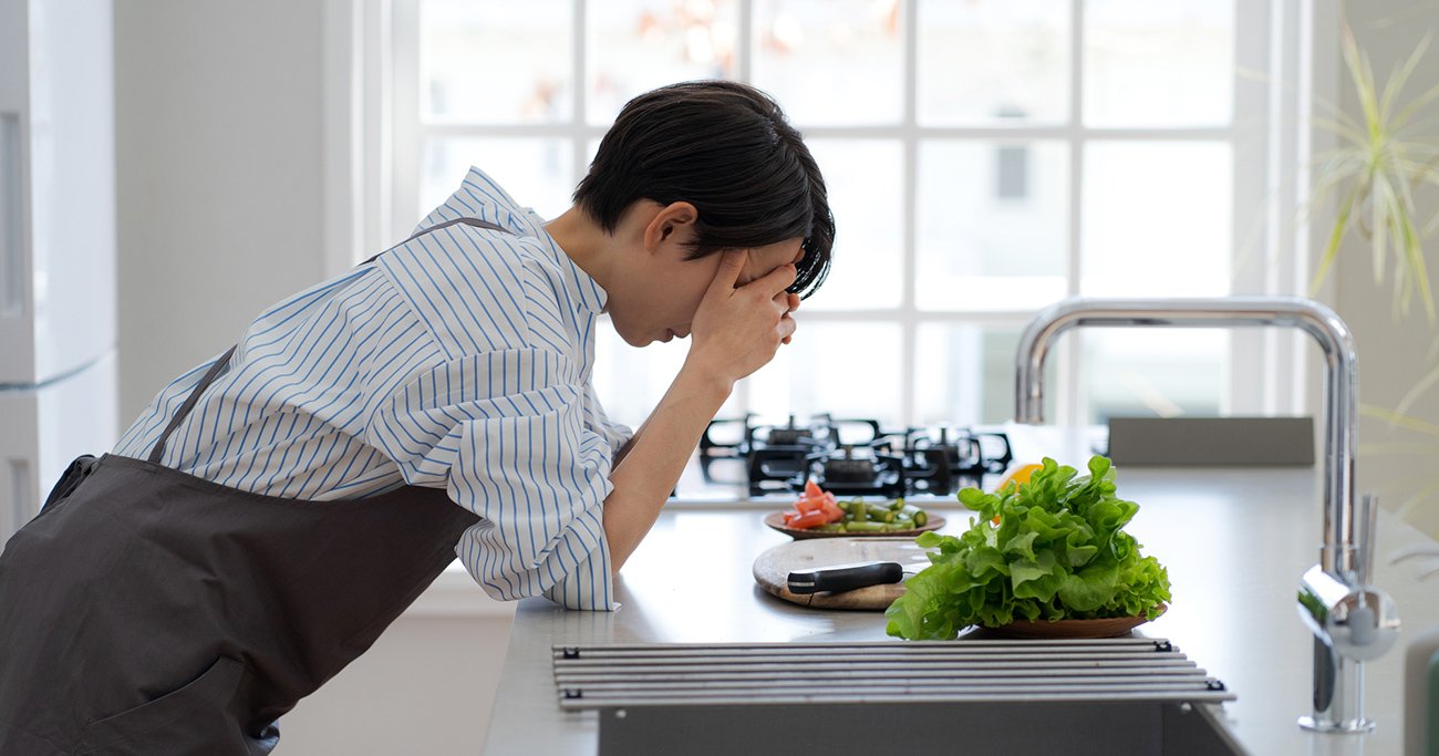 キッチンでうつむく女性