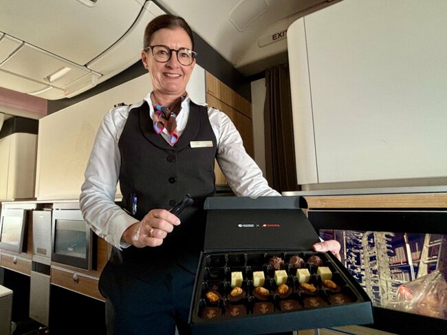 客室乗務員が箱入りのアッシュバッハ ショコラティエのチョコレートを配ってくれる