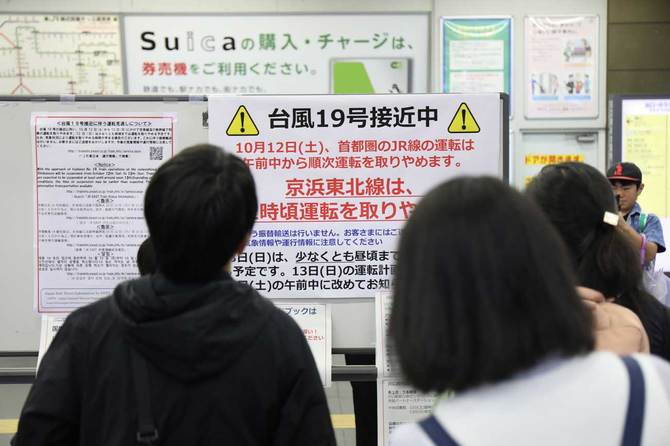 計画運休の貼り紙を見る乗客たち